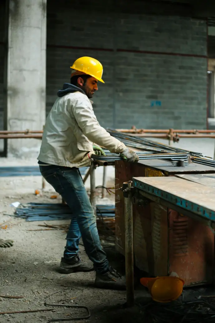 a man in a hard hat working on a piece of metal